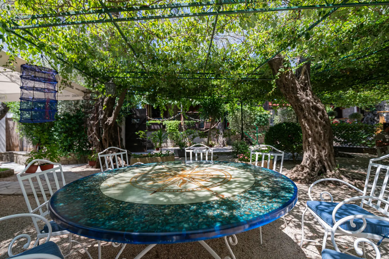 The blue mosaic table under the pergola